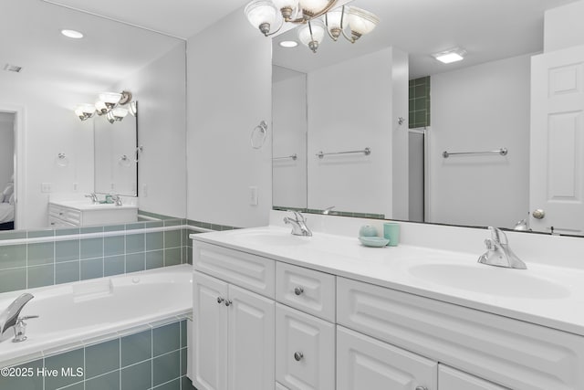 2555 St James Dr SE Unit 102, Southport, NC 28461 - bathroom with double vanity, a bath, a chandelier, and recessed lighting