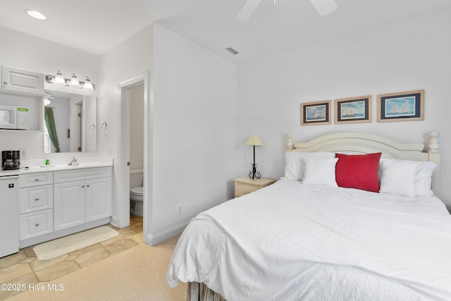2555 St James Dr SE Unit 102, Southport, NC 28461 - bedroom featuring a sink, ensuite bath, and ceiling fan