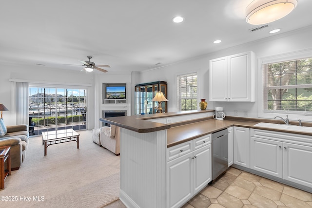 2555 St James Dr SE Unit 102, Southport, NC 28461 - kitchen featuring open floor plan, stainless steel dishwasher, a sink, a peninsula, and dark countertops