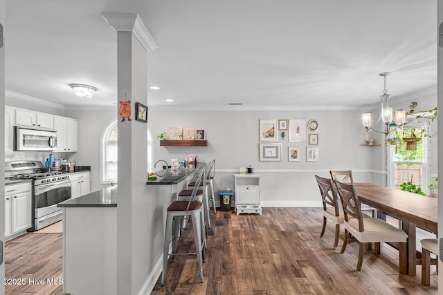912 Morganser Dr, Swansboro, NC 28584 - dining room with dark wood finished floors, a chandelier, crown molding, and recessed lighting