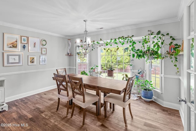 912 Morganser Dr, Swansboro, NC 28584 - dining area with a chandelier, wood finished floors, baseboards, and crown molding