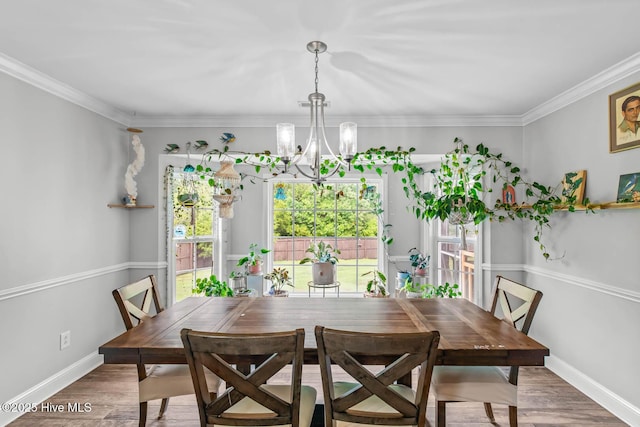 912 Morganser Dr, Swansboro, NC 28584 - dining space with healthy amount of natural light, a chandelier, wood finished floors, and ornamental molding