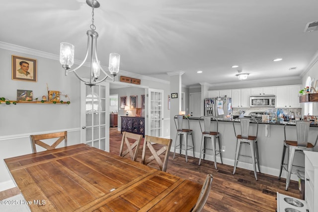 912 Morganser Dr, Swansboro, NC 28584 - dining room featuring french doors, ornamental molding, dark wood-type flooring, recessed lighting, and a chandelier