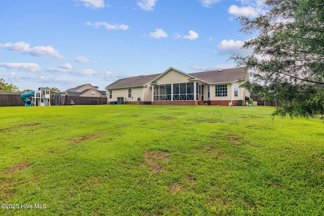912 Morganser Dr, Swansboro, NC 28584 - rear view of property with a sunroom, a playground, and a yard