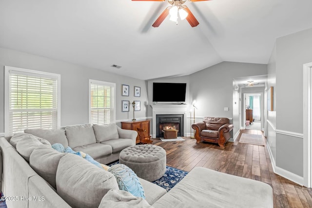 912 Morganser Dr, Swansboro, NC 28584 - living room with a ceiling fan, wood-type flooring, vaulted ceiling, baseboards, and a warm lit fireplace