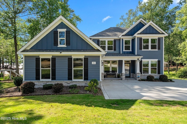 106 Josephs Pt, West End, NC 27376 - rear view of house featuring board and batten siding, a porch, stone siding, a lawn, and roof with shingles