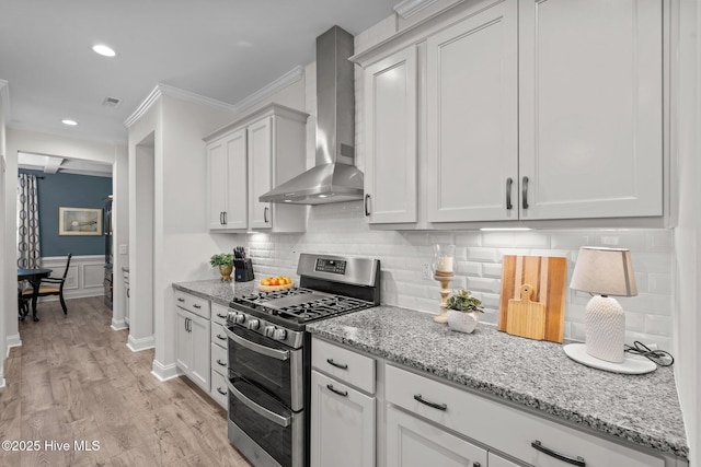 106 Josephs Pt, West End, NC 27376 - kitchen featuring range with two ovens, wall chimney range hood, crown molding, light stone countertops, and light wood-type flooring