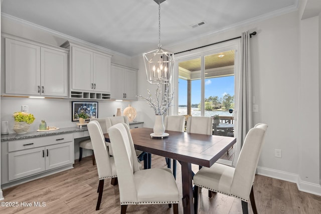 106 Josephs Pt, West End, NC 27376 - dining room with a water view, light wood-style flooring, a chandelier, crown molding, and built in desk