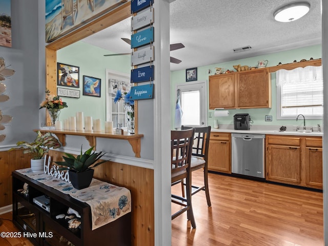 500 Nutfield Dr, Hubert, NC 28539 - kitchen with stainless steel dishwasher, a sink, a ceiling fan, light countertops, and a textured ceiling