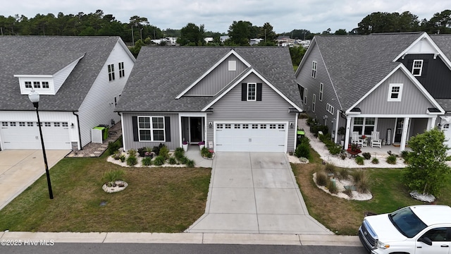 5920 Appomattox Dr, Wilmington, NC 28409 - view of front of home with board and batten siding, driveway, roof with shingles, and a front lawn