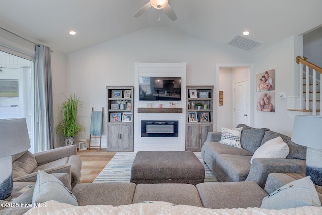 5920 Appomattox Dr, Wilmington, NC 28409 - living area with vaulted ceiling, a ceiling fan, wood finished floors, stairs, and a glass covered fireplace