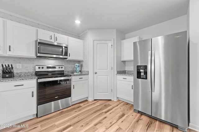 3402 Woodwind Ct, Kinston, NC 28504 - kitchen with stainless steel appliances, light wood-style flooring, white cabinets, light stone counters, and recessed lighting