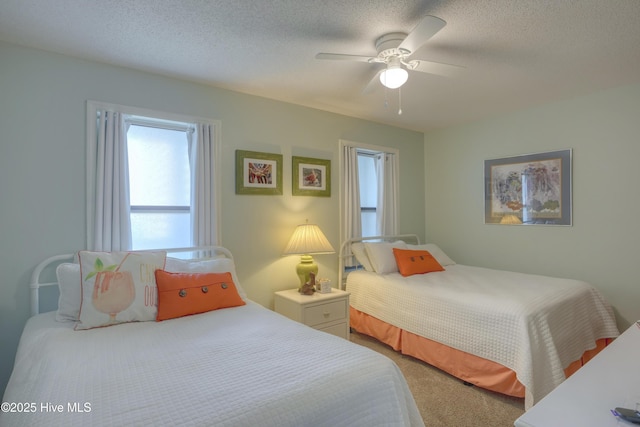 1896 New River Inlet Rd Unit 1212, North Topsail Beach, NC 28460 - bedroom featuring multiple windows, carpet floors, ceiling fan, and a textured ceiling