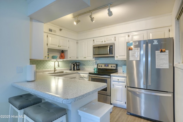 1896 New River Inlet Rd Unit 1212, North Topsail Beach, NC 28460 - kitchen with appliances with stainless steel finishes, a sink, a peninsula, white cabinets, and light countertops