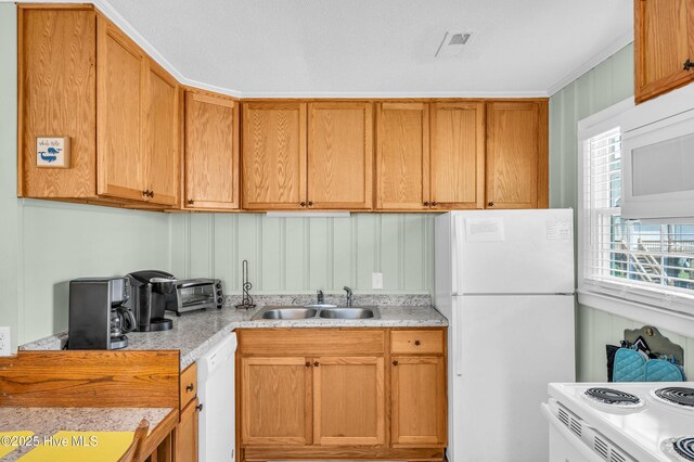 1020 Carolina Beach Ave N, Carolina Beach, NC 28428 - kitchen with white appliances, light countertops, and brown cabinetry