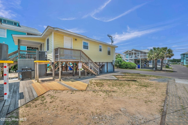 1020 Carolina Beach Ave N, Carolina Beach, NC 28428 - rear view of property featuring stairs, a wooden deck, an attached garage, and driveway