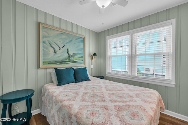 1020 Carolina Beach Ave N, Carolina Beach, NC 28428 - bedroom featuring a decorative wall, dark wood-type flooring, ornamental molding, and a ceiling fan