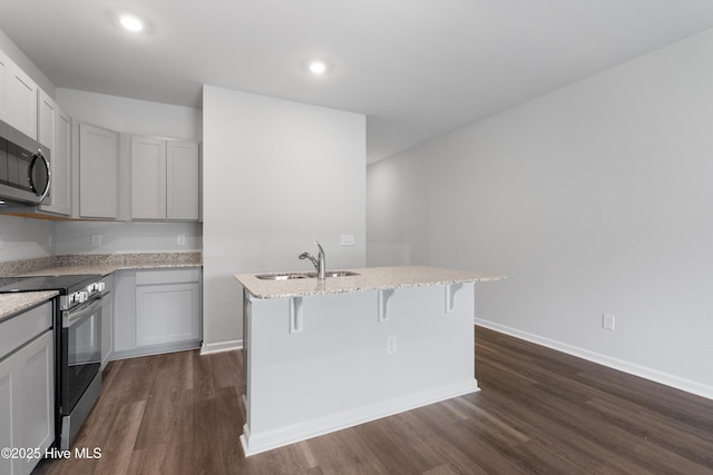 250 Arnette Dr Unit 83B, Ocean Isle Beach, NC 28469 - kitchen featuring stainless steel appliances, a sink, dark wood-style flooring, an island with sink, and a kitchen breakfast bar