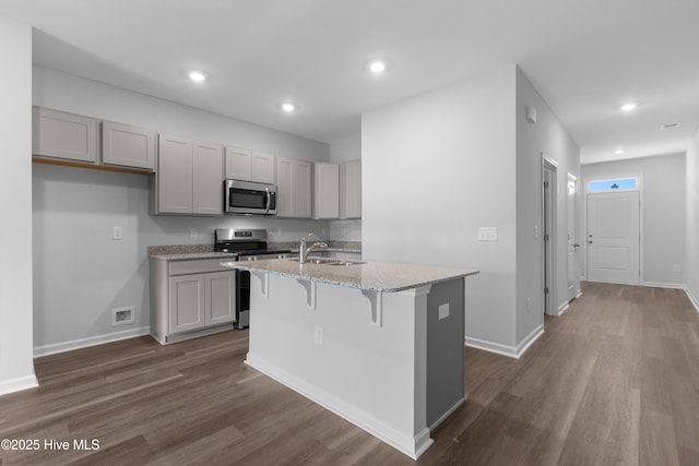 250 Arnette Dr Unit 83B, Ocean Isle Beach, NC 28469 - kitchen with appliances with stainless steel finishes, dark wood finished floors, a sink, a center island with sink, and recessed lighting