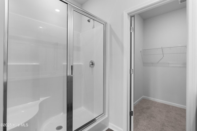 250 Arnette Dr Unit 83B, Ocean Isle Beach, NC 28469 - bathroom with a shower stall, a walk in closet, and baseboards
