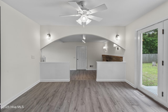 352 Brenda Dr, Wilmington, NC 28409 - unfurnished living room with arched walkways, wood finished floors, a ceiling fan, and baseboards