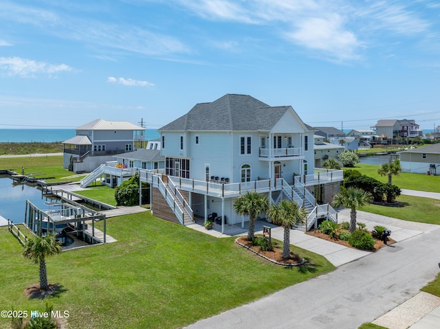 306 Marina Way N, Topsail Beach, NC 28460 - back of house featuring stairs, concrete driveway, a water view, roof with shingles, and a balcony