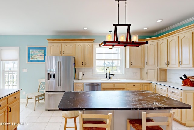 306 Marina Way N, Topsail Beach, NC 28460 - kitchen with appliances with stainless steel finishes, light brown cabinetry, a kitchen breakfast bar, a sink, and a chandelier