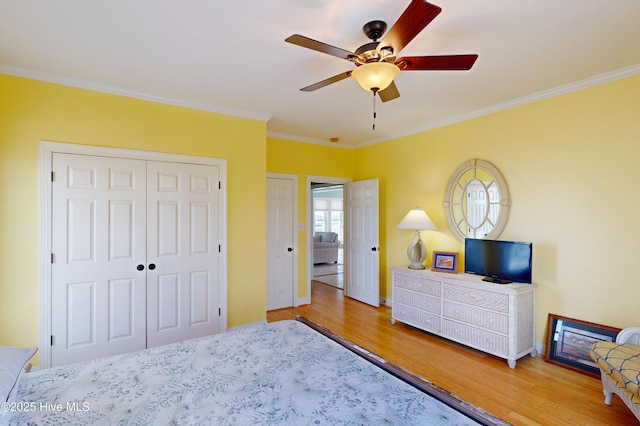 306 Marina Way N, Topsail Beach, NC 28460 - bedroom featuring wood finished floors, crown molding, a closet, baseboards, and ceiling fan