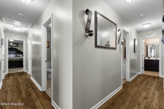 700 Stafford Ln, Jacksonville, NC 28546 - hallway with dark wood-style flooring, baseboards, and attic access