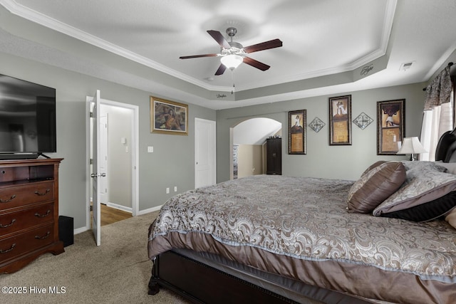 700 Stafford Ln, Jacksonville, NC 28546 - bedroom featuring a raised ceiling, carpet floors, crown molding, arched walkways, and baseboards