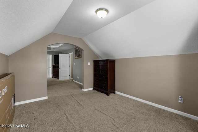 700 Stafford Ln, Jacksonville, NC 28546 - additional living space with carpet flooring, lofted ceiling, arched walkways, baseboards, and a textured ceiling