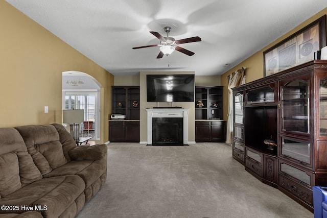 700 Stafford Ln, Jacksonville, NC 28546 - living room featuring a ceiling fan, arched walkways, light colored carpet, and a fireplace with flush hearth