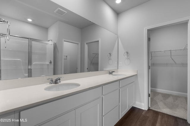 254 Arnette Dr Unit 82B, Shallotte, NC 28469 - bathroom featuring a shower stall, a spacious closet, double vanity, wood finished floors, and recessed lighting