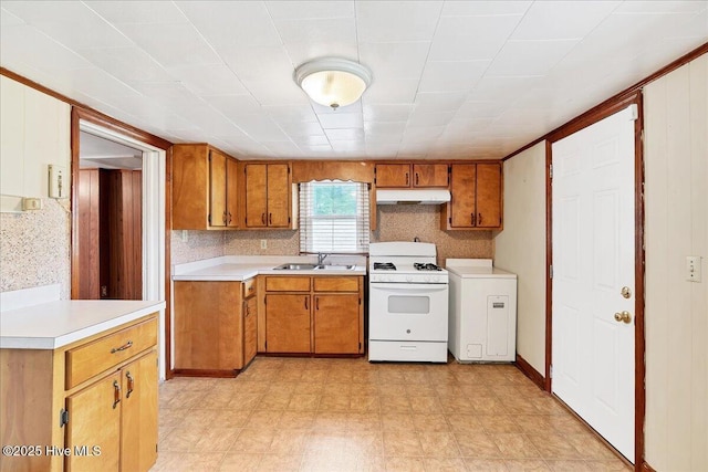 110 Texanna Ln, Raeford, NC 28376 - kitchen with white gas stove, under cabinet range hood, brown cabinetry, and light countertops