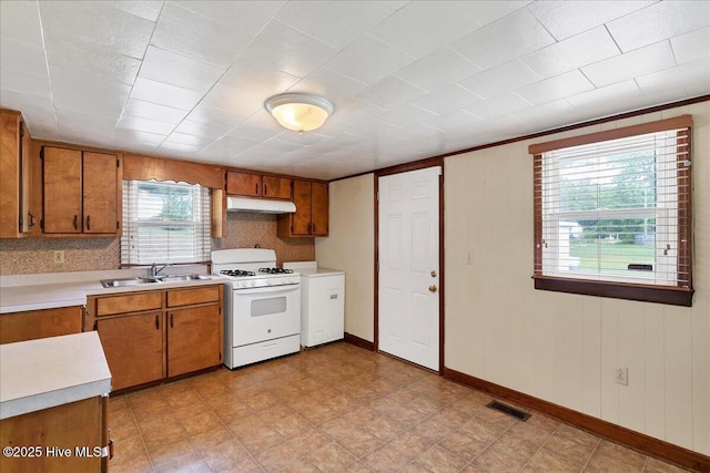 110 Texanna Ln, Raeford, NC 28376 - kitchen with white gas stove, brown cabinetry, and light countertops