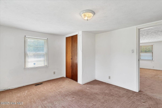 110 Texanna Ln, Raeford, NC 28376 - unfurnished bedroom with carpet, a textured ceiling, multiple windows, baseboards, and a closet