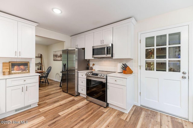 1809 E Indiana Ave, Southern Pines, NC 28387 - kitchen featuring appliances with stainless steel finishes, light countertops, light wood-style floors, white cabinetry, and recessed lighting
