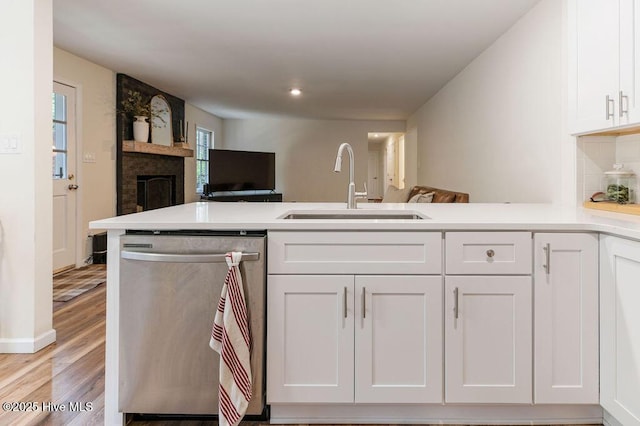 1809 E Indiana Ave, Southern Pines, NC 28387 - kitchen featuring stainless steel dishwasher, a sink, open floor plan, white cabinetry, and a peninsula