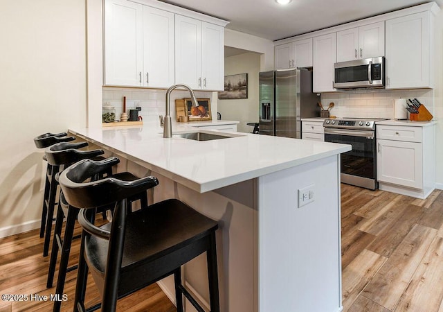 1809 E Indiana Ave, Southern Pines, NC 28387 - kitchen featuring stainless steel appliances, a sink, tasteful backsplash, and a breakfast bar