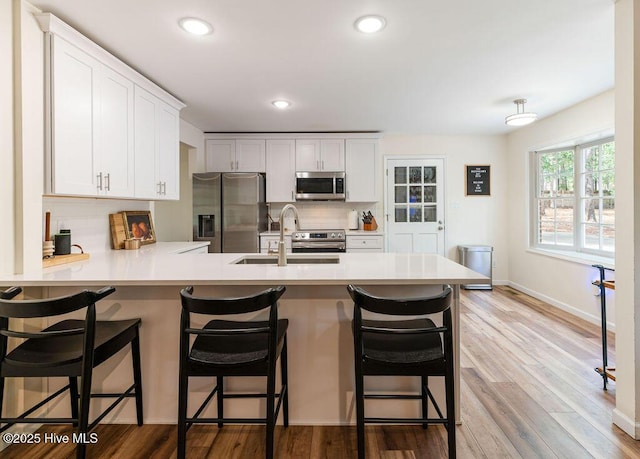 1809 E Indiana Ave, Southern Pines, NC 28387 - kitchen with appliances with stainless steel finishes, a sink, backsplash, light countertops, and a peninsula