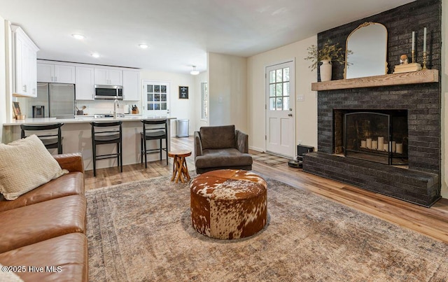 1809 E Indiana Ave, Southern Pines, NC 28387 - living room featuring light wood finished floors, a brick fireplace, and recessed lighting