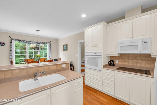 423 White Columns Way, Wilmington, NC 28411 - kitchen featuring white appliances, a sink, crown molding, hanging light fixtures, and white cabinets