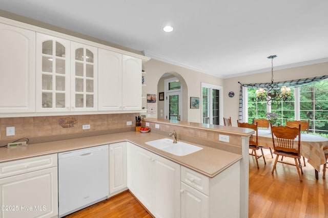 423 White Columns Way, Wilmington, NC 28411 - kitchen featuring white dishwasher, a sink, a peninsula, ornamental molding, and light wood-style flooring