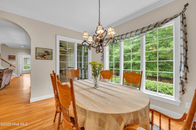 423 White Columns Way, Wilmington, NC 28411 - dining space featuring baseboards, a chandelier, arched walkways, stairway, and crown molding