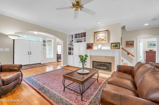 423 White Columns Way, Wilmington, NC 28411 - living room with arched walkways, light wood-type flooring, a ceiling fan, built in shelves, and crown molding