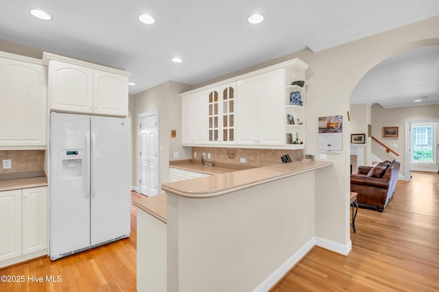 423 White Columns Way, Wilmington, NC 28411 - kitchen with white refrigerator with ice dispenser, arched walkways, light wood-style flooring, decorative backsplash, and recessed lighting