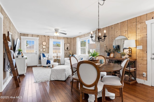 2767 Nags Head Rd SW, Supply, NC 28462 - dining room featuring dark wood-style flooring, a chandelier, ceiling fan, and wooden walls