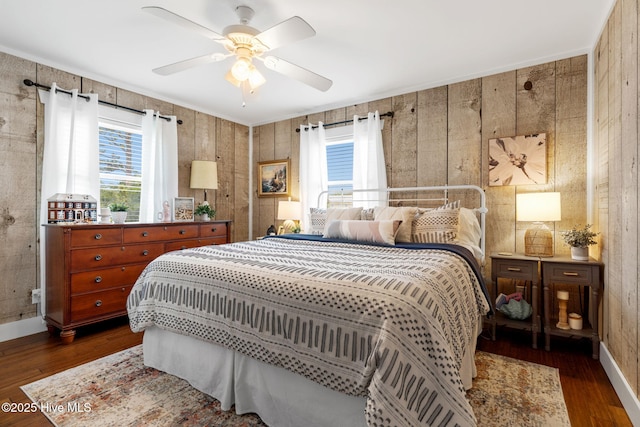 2767 Nags Head Rd SW, Supply, NC 28462 - bedroom with multiple windows, dark wood-type flooring, wood walls, and a ceiling fan