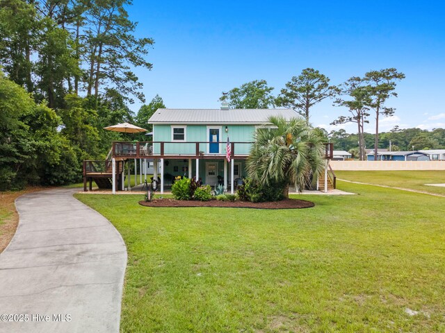 2767 Nags Head Rd SW, Supply, NC 28462 - coastal inspired home featuring a wooden deck, a front lawn, metal roof, and stairway