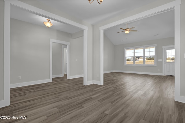 141 Talbert Dr, Rocky Point, NC 28457 - unfurnished living room featuring dark wood-style floors, vaulted ceiling, baseboards, a ceiling fan, and a chandelier